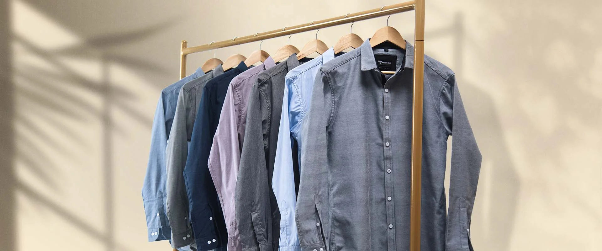 Row of shirts on hangers against a neutral background